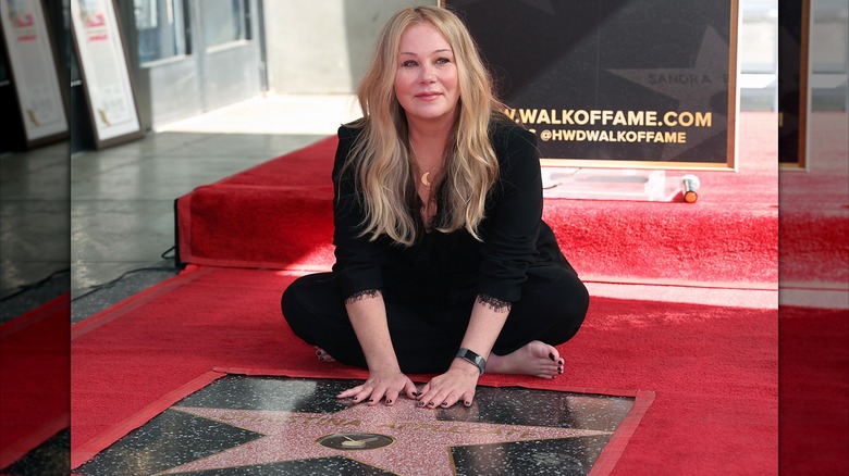Christina Applegate sitting alongside her star on the Hollywood Walk of Fame in 2022