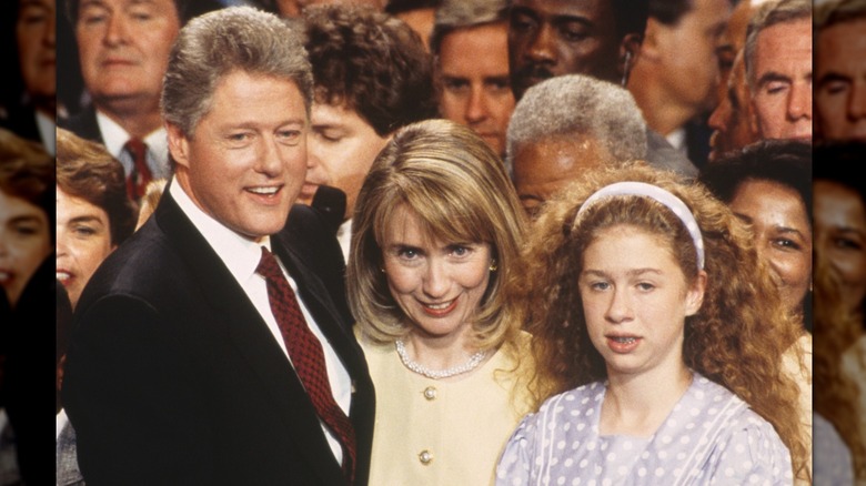A young Chelsea Clinton with her mom and dad at a political event around 1992