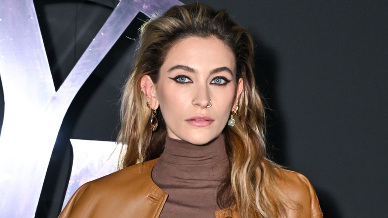 Paris Jackson posing on the red carpet with her long hair pushed back in 2024