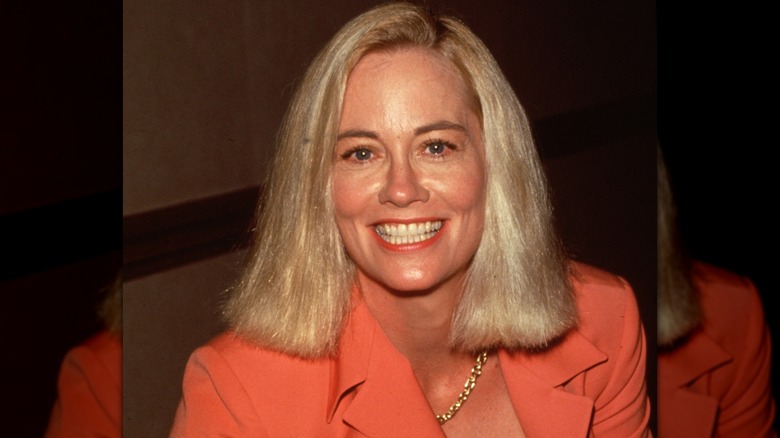 Cybill Shepherd smiling in a 1995 picture wearing an orange blazer