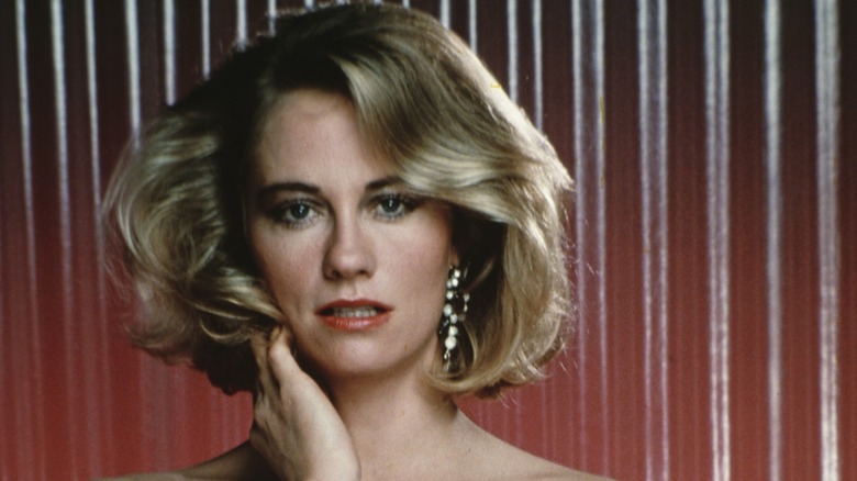 Cybill Shepherd posing for a photoshoot in front of a red background 1985