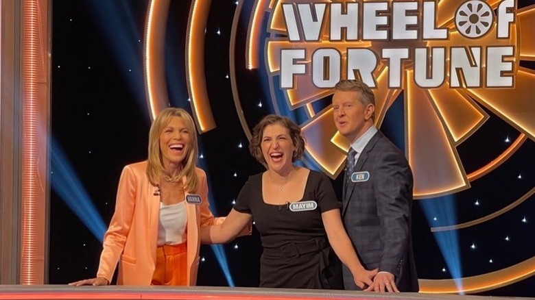 Vanna White laughing with Mayim Bialik and Ken Jennings on Celebrity Wheel of Fortune in 2023