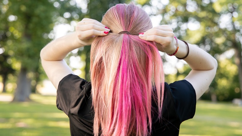 A woman with a hair tie on her wrist and in her hair