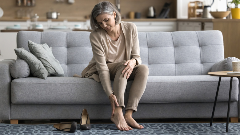 A woman holding feet after taking off stilettos