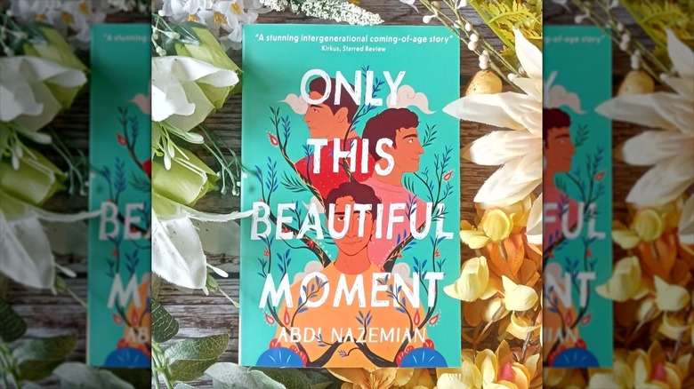 A copy of "Only This Beautiful Moment" surrounded by flowers