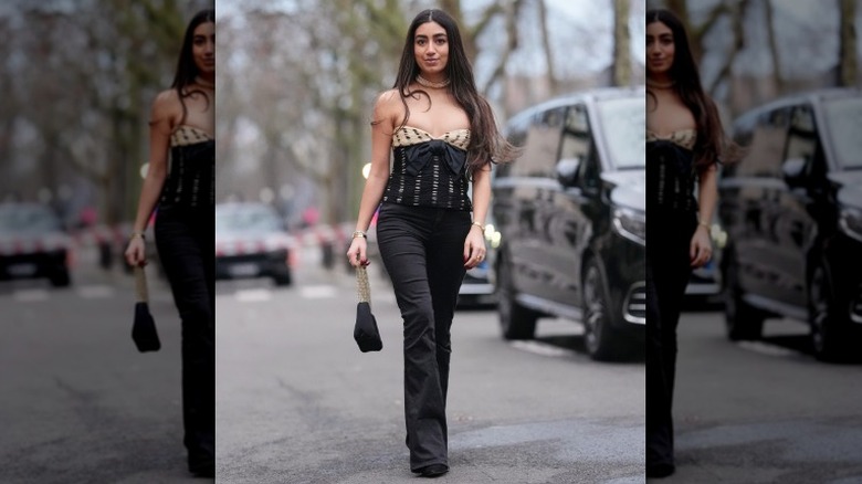 A woman wearing full length black jeans on the street