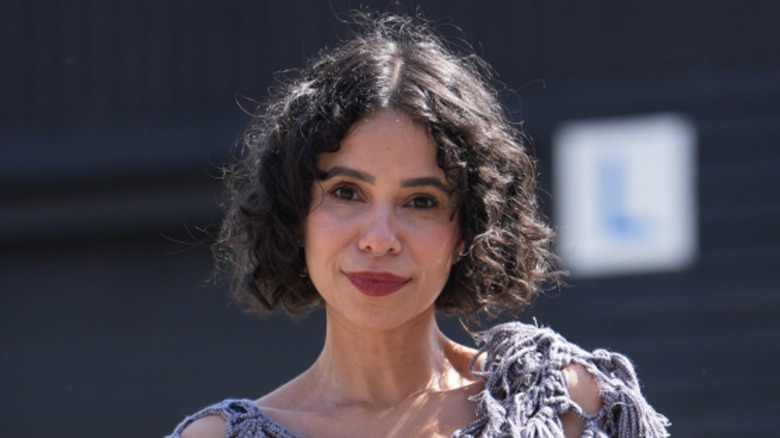 A woman with a neutral expression and a curly bob
