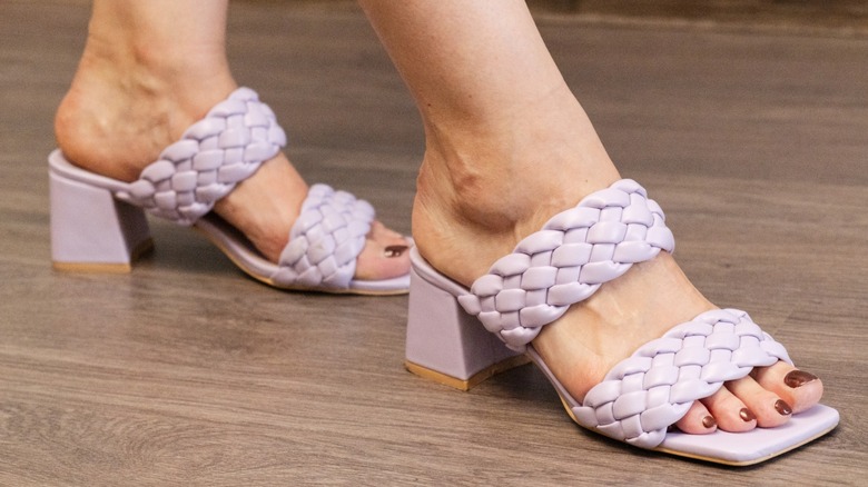 A woman wearing lilac, square-toe slingback heels