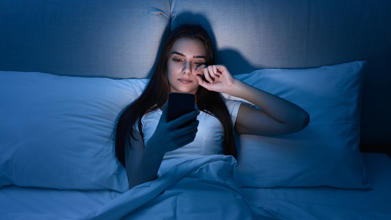 woman on iphone in bed