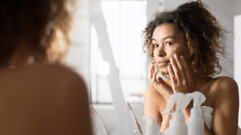 Woman putting on eye cream 
