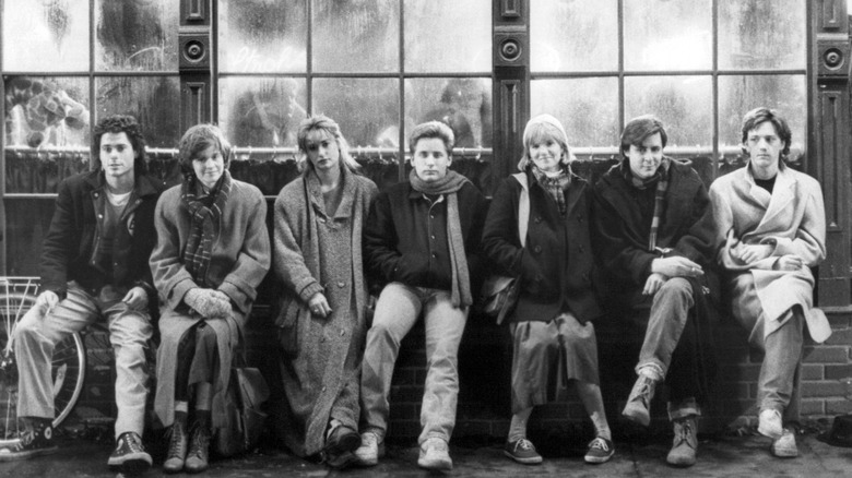 A black-and-white photo of the cast of "St. Elmo's Fire" sitting outside on a brick wall