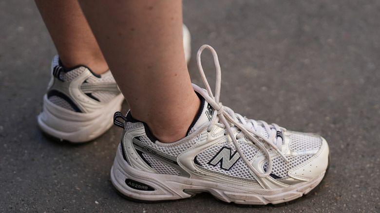 Person wearing white and silver mesh 530 New Balance sneakers
