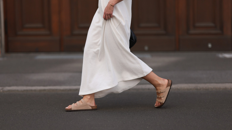 Woman wearing a white dress and beige Birkenstocks