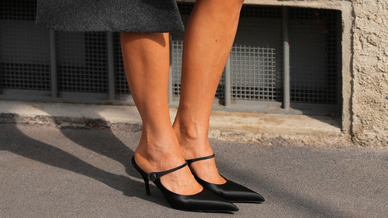 Woman wearing black pointed mesh and leather heels