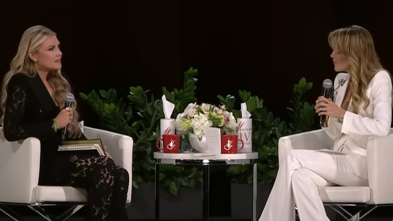 Erika Kirk in a lace pantsuit on stage with Megyn Kelly