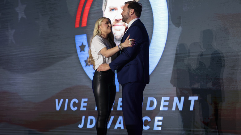 Erika Kirk in leather pants holding JD Vance on stage