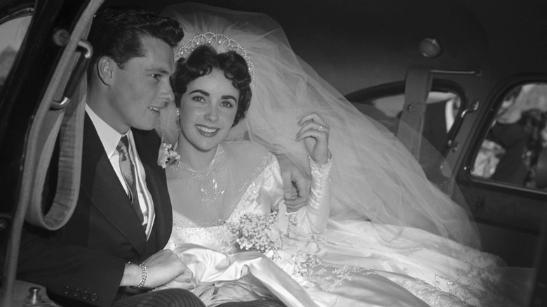 Elizabeth Taylor seated and leaning back against a couch