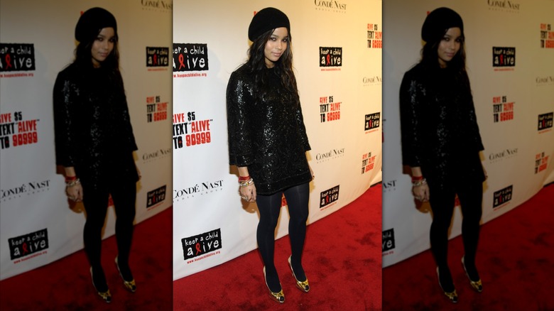 Zoë Kravitz poses wearing a black sequin dress and a black beanie