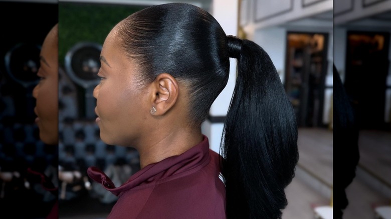 A woman with black hair pulled into a slicked down ponytail