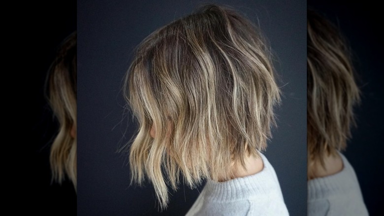 A woman with a blond bob styled into beach waves