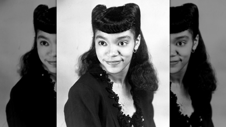 Vintage photograph of a young woman from the 1940s wearing victory rolls in her hair