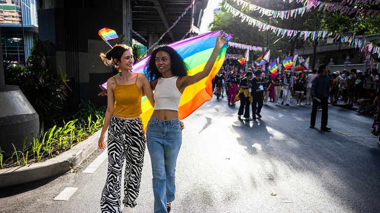 People walking with rainbow flag