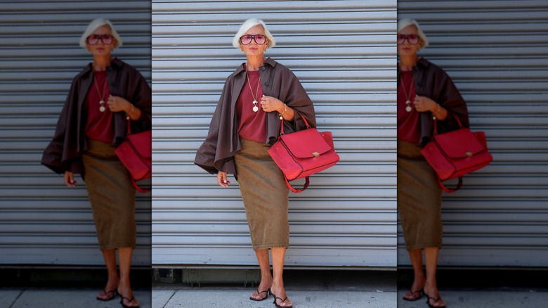 Grace Gengham poses for a photo at NYFW in a denim pencil skirt, red top, open-toe sandals with a cropped trench-style jacket