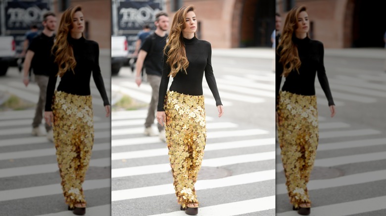 Giulia Be is seen wearing a Patbo black sheer top and gold sequin maxi skirt outside of the Patbo show, during New York Fashion Week