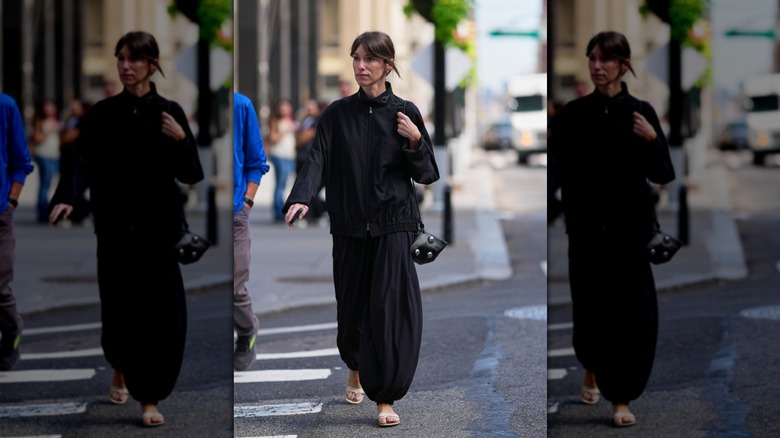 A guest of NYFW wears a black jacket with oversized balloon pants