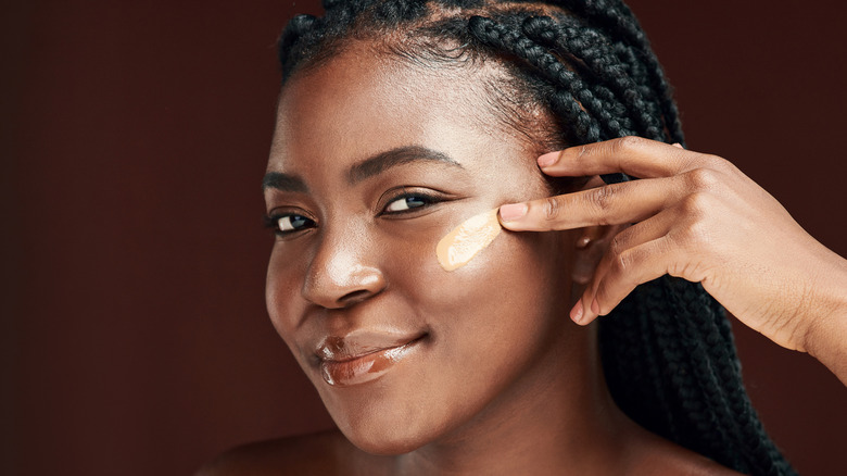 Woman applying concealer