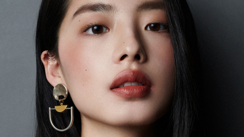 Model wearing statement earrings