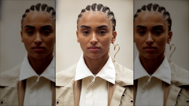 A woman with a big heart earring and a white collar shirt
