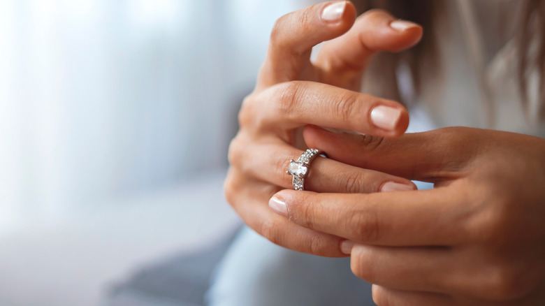 woman taking off her wedding ring