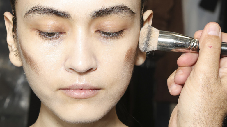 Makeup artist applies contour
