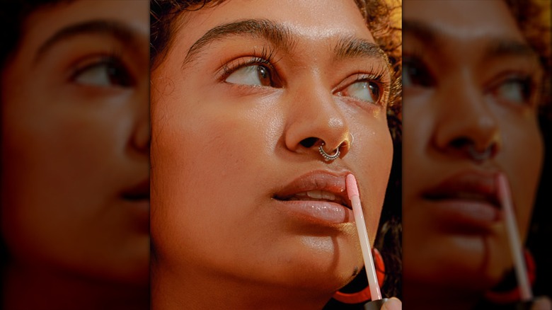 Woman applies lip oil
