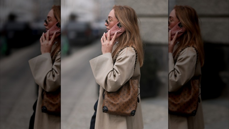 Sonia Lyson carrying a Louis Vuitton brown logo monogram pattern bucket bag with gold chain straps