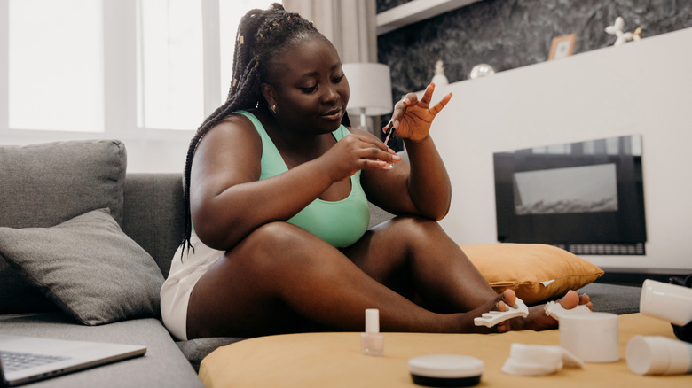 Woman painting her toenails at home