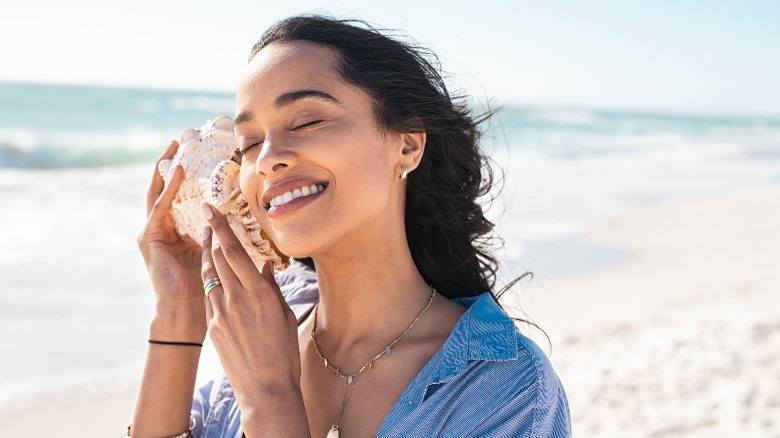 Woman listens to seashell