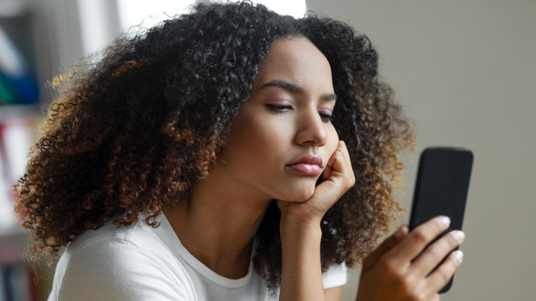 Unhappy woman looking at phone