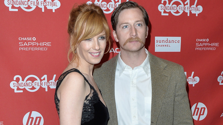 Kelly Reilly smiles in a black dress next to her husband, Kyle Baugher