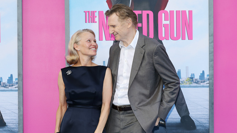 Pamela Anderson and Liam Neeson smiling at an event