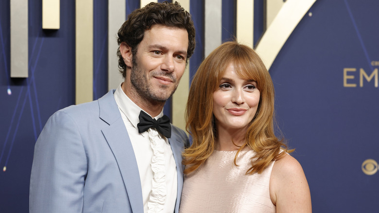 Adam Brody and Leighton Meester smiling while posing at the 2025 Emmys