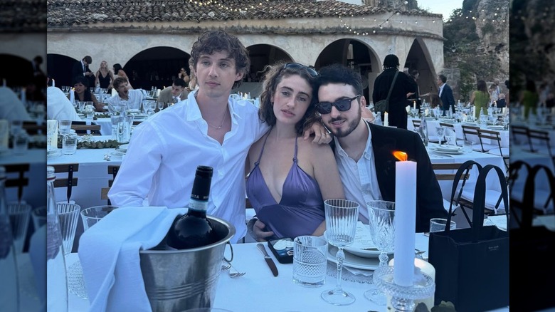 Troye Sivan posing with rumored couple Rachel Sennott and Blake Slatkin at a wedding event