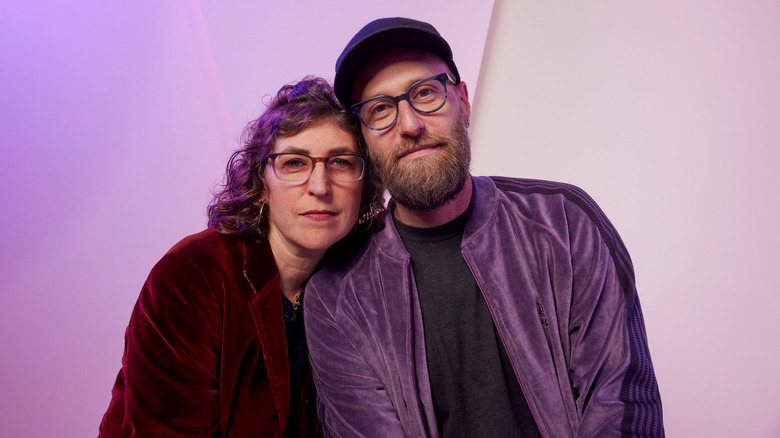 Mayim Bialik leaning on the shoulder of Jonathan Cohen