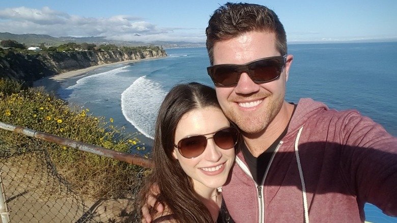Daniela Bobadilla and Beau Wirick posing together above a beach