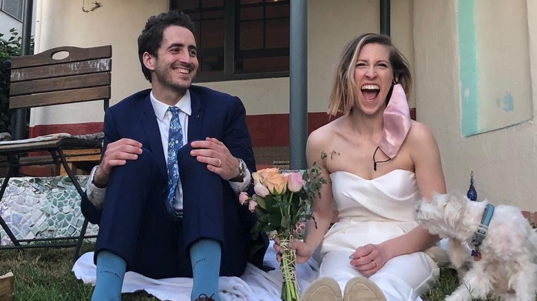 Eden Sher sitting on the grass with Nick Cron-DeVico on their wedding day