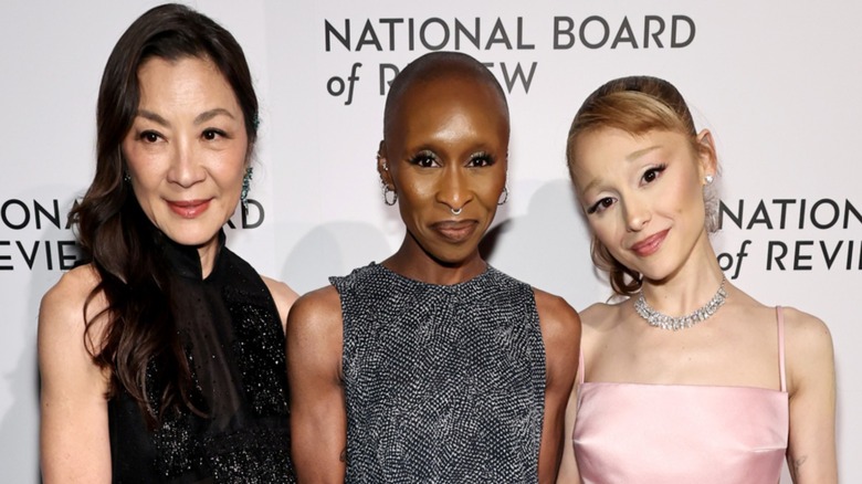 Michelle Yeoh, Cynthia Erivo, and Ariana Grande posing together on the red carpet