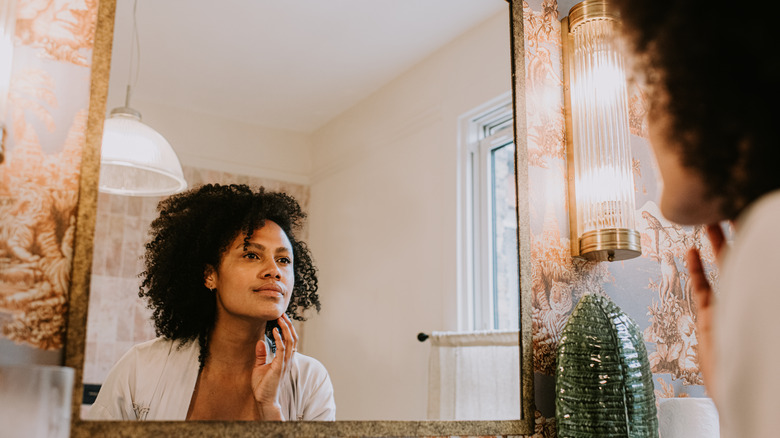 Woman with curly hair looking in the mirror