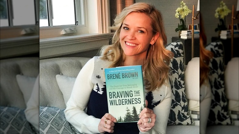 Reese Witherspoon holding a copy of Braving the Wilderness