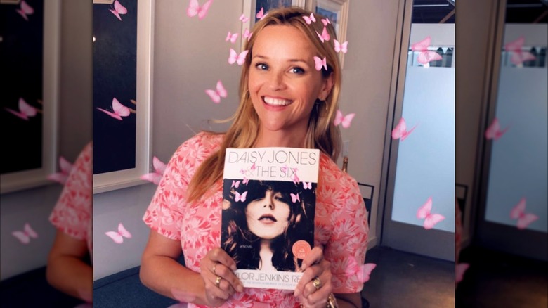 Reese Witherspoon holding a copy of Daisy Jones & The Six